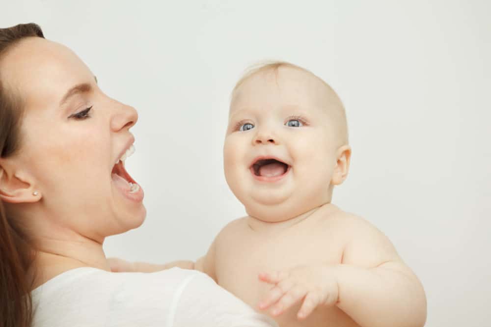 Mama trzyma niemowlę, które zaczyna mówić