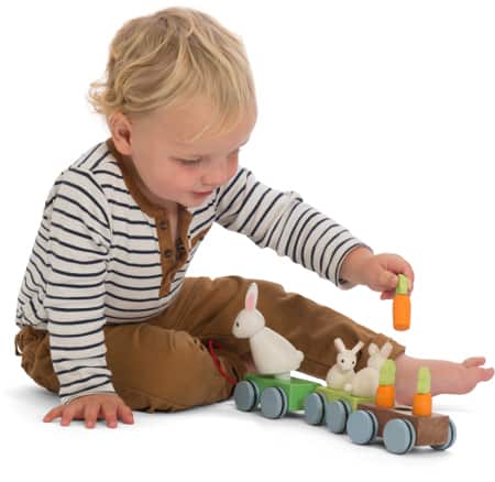 Chłopczyk z drewnianym pociągiem do ciągnięcia